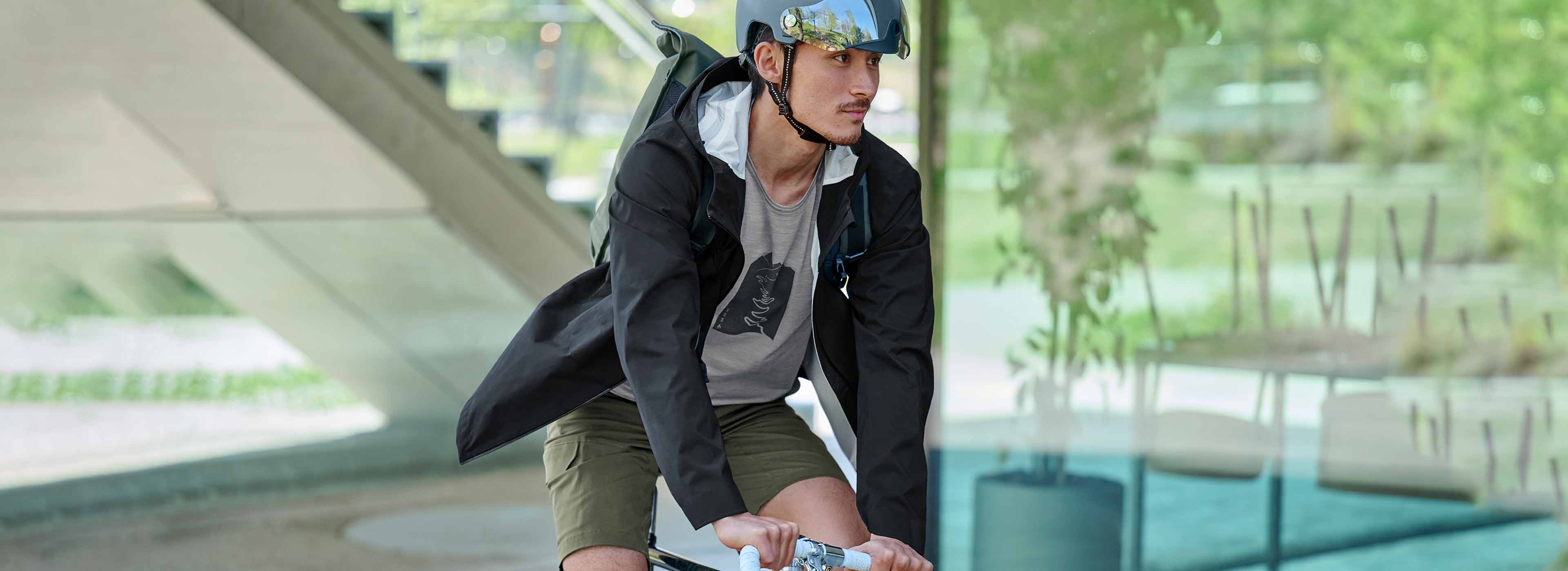 a man on a city bike, wearing a t-shirt and jacket designed for bike commuting