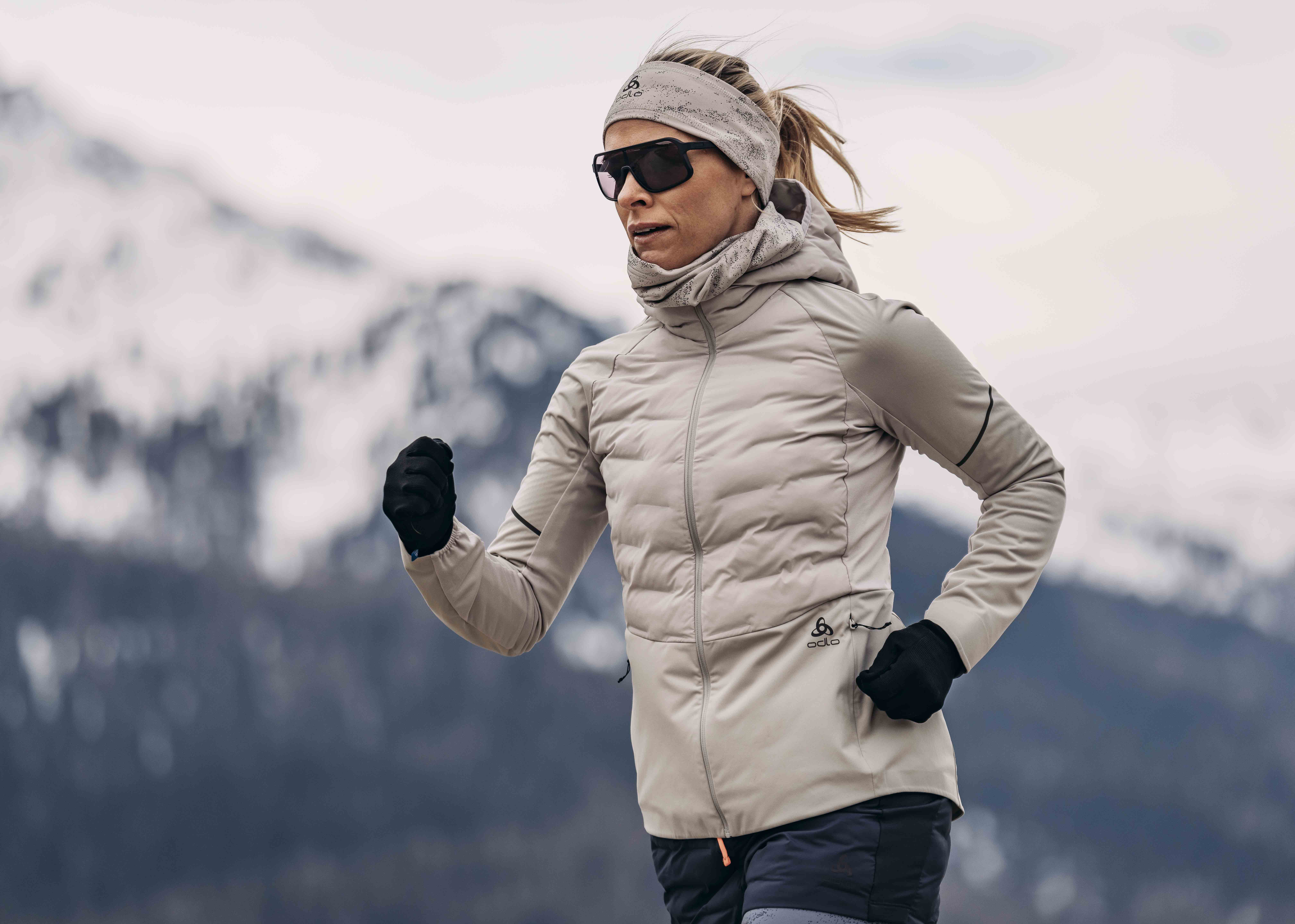 A landscape image of a woman wearing an Zeroweight running jacket