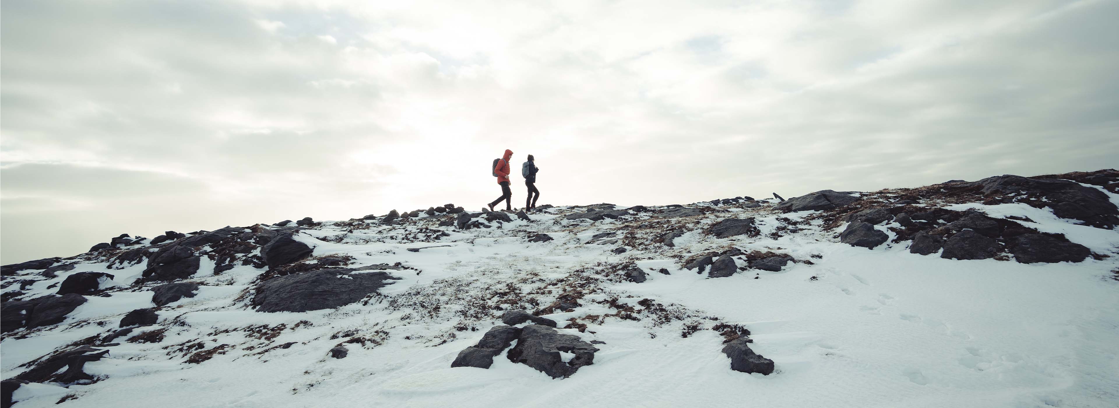 Men and women hiking in the snow with outdoor clothing